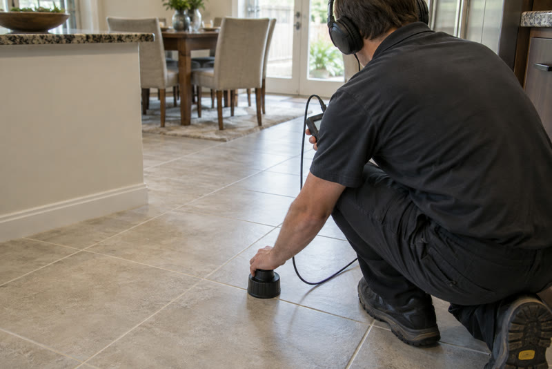 Acoustic floor microphone resting on intact tile during a slab leak investigation.